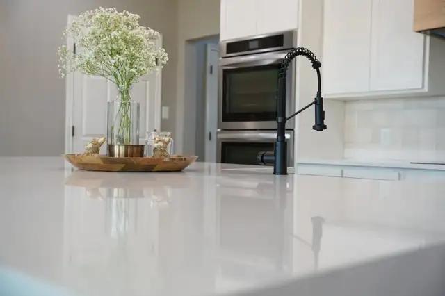 Farmhouse Road kitchen in Midland with white cabinetry, a stone countertop, black faucet and stainless double wall ovens