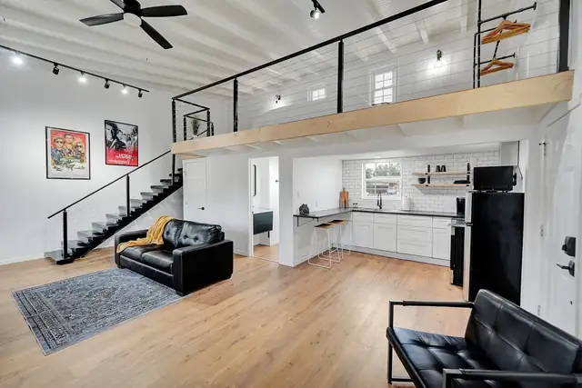 Michigan Residence whole-home remodel in Midland with an open living area, wood floors, a loft and black metal railings